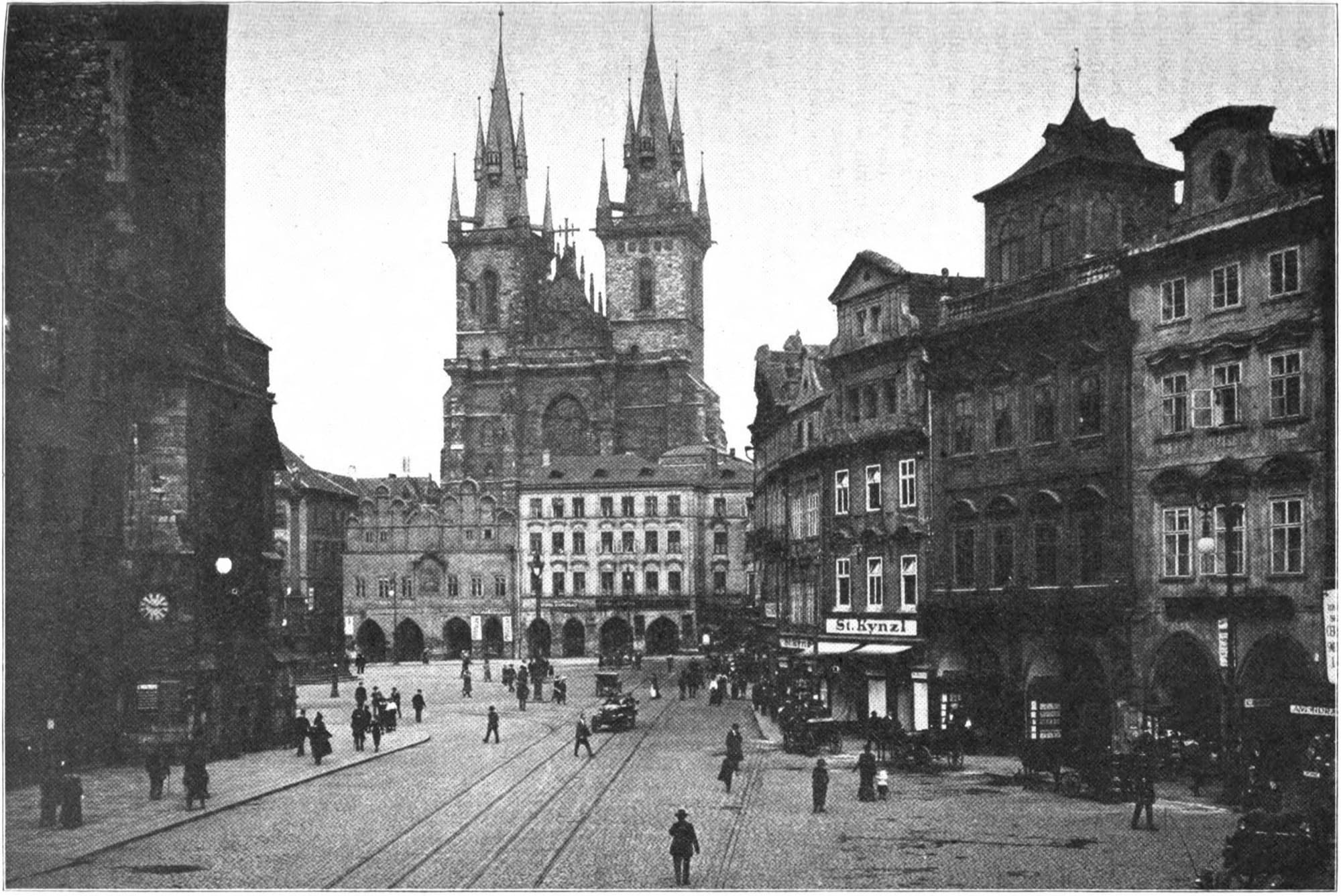 Old Town Square in Prague photographed around 1920, with the twin spires of the Týn Church rising behind the rooftops